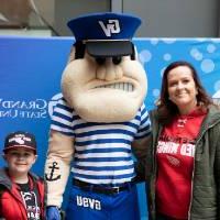 An alumna and her child pose with Louie the Laker at the Detroit Red Wings GVSU Night